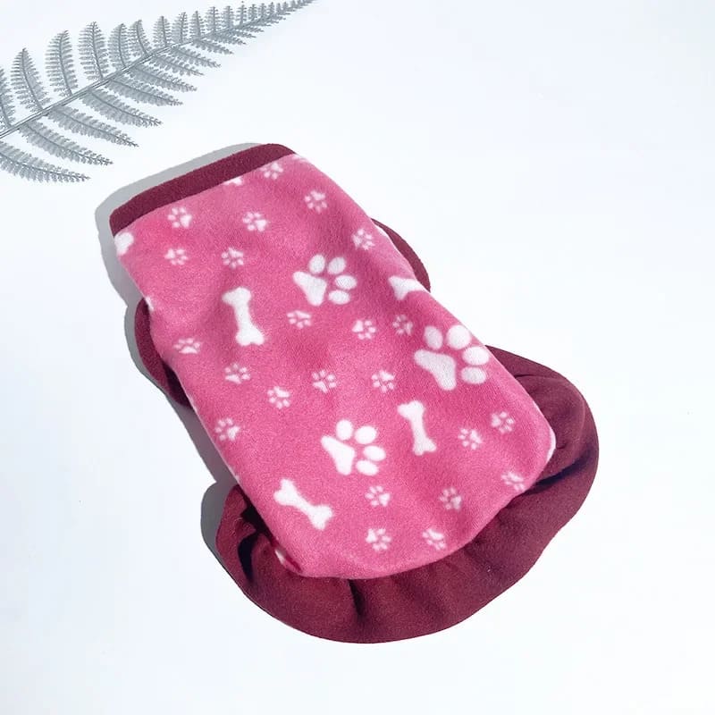 Cozy pink fleece jacket for pooches adorned with white paw and bone patterns, perfect for keeping your furry friend warm in style